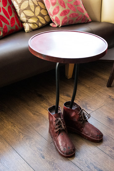 A table wearing a pair of boots. Photo credit - Welcome Back Fund